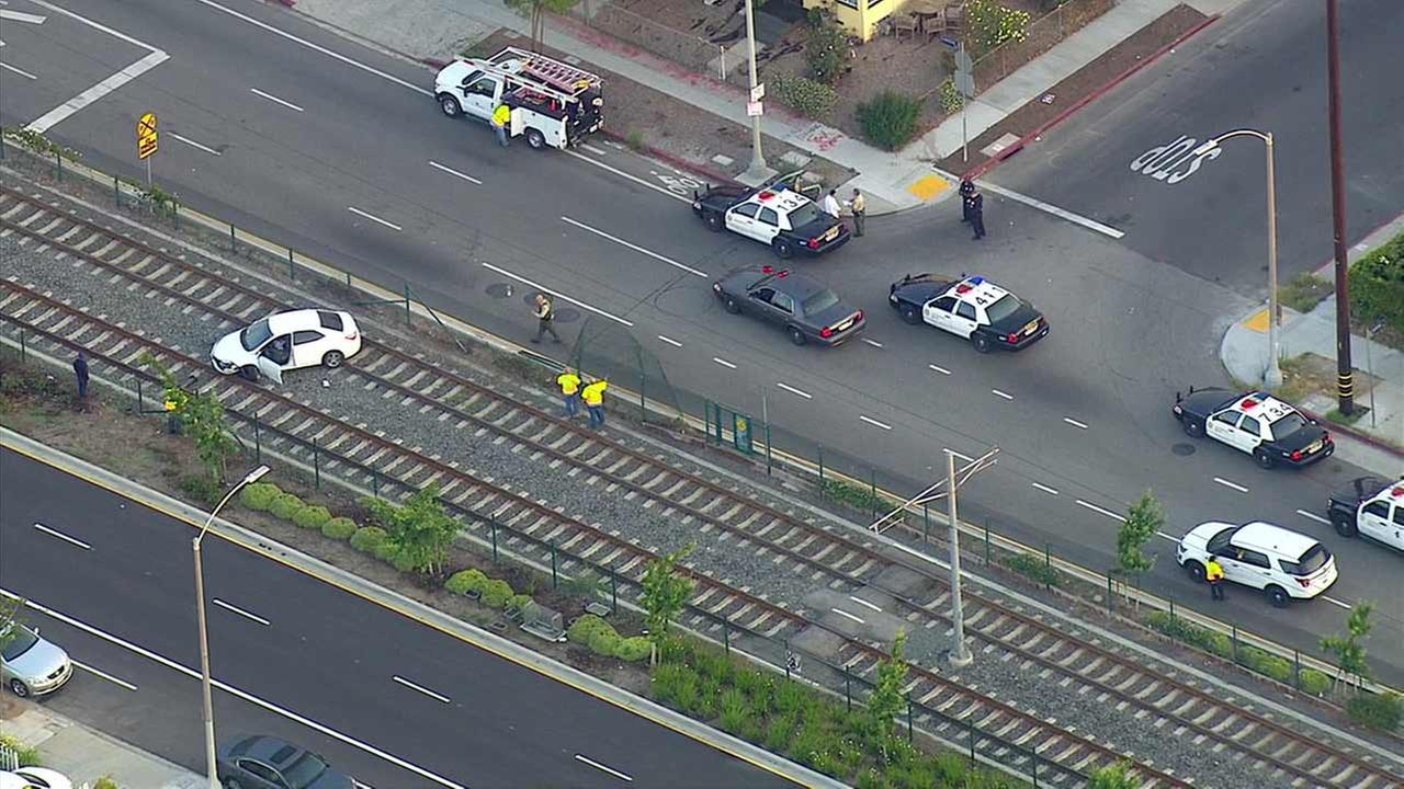 Car gets stuck on Expo Line tracks after crashing through fence in